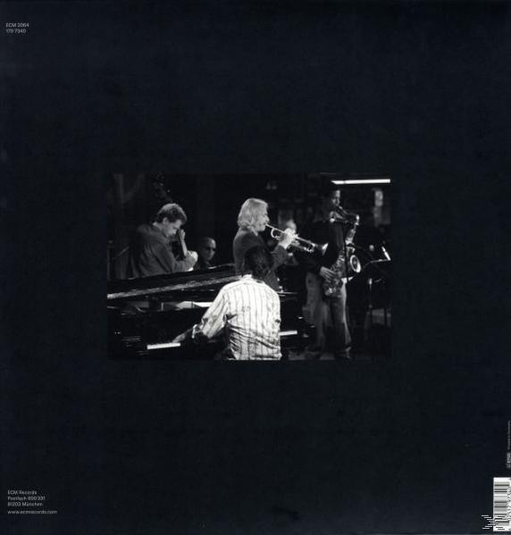Een zwart-wit foto van jazzmuzikanten die instrumenten bespelen. Een pianist, trompettist, saxofonist.
