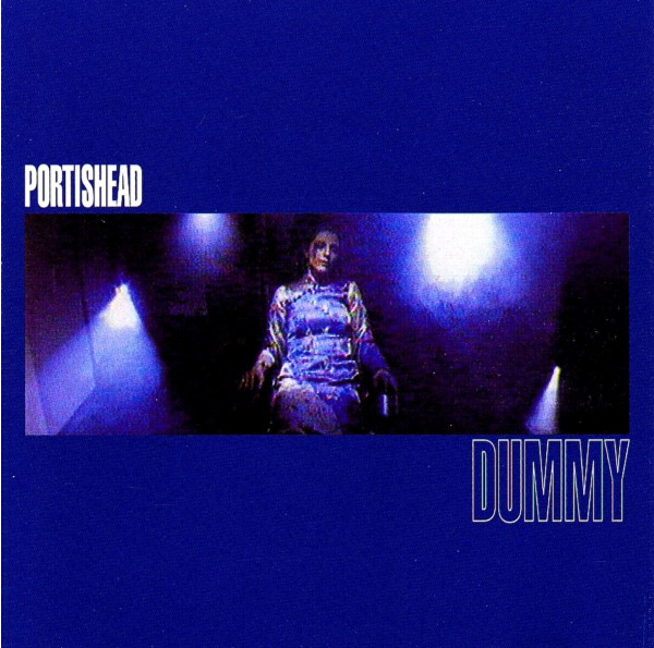 Album cover. A woman in a blue dress sits in a room. The word DUMMY is written below.
