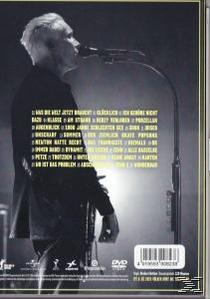 Ein Mann mit Mikrofon singt. Der Hintergrund zeigt eine Liste von Titeln.