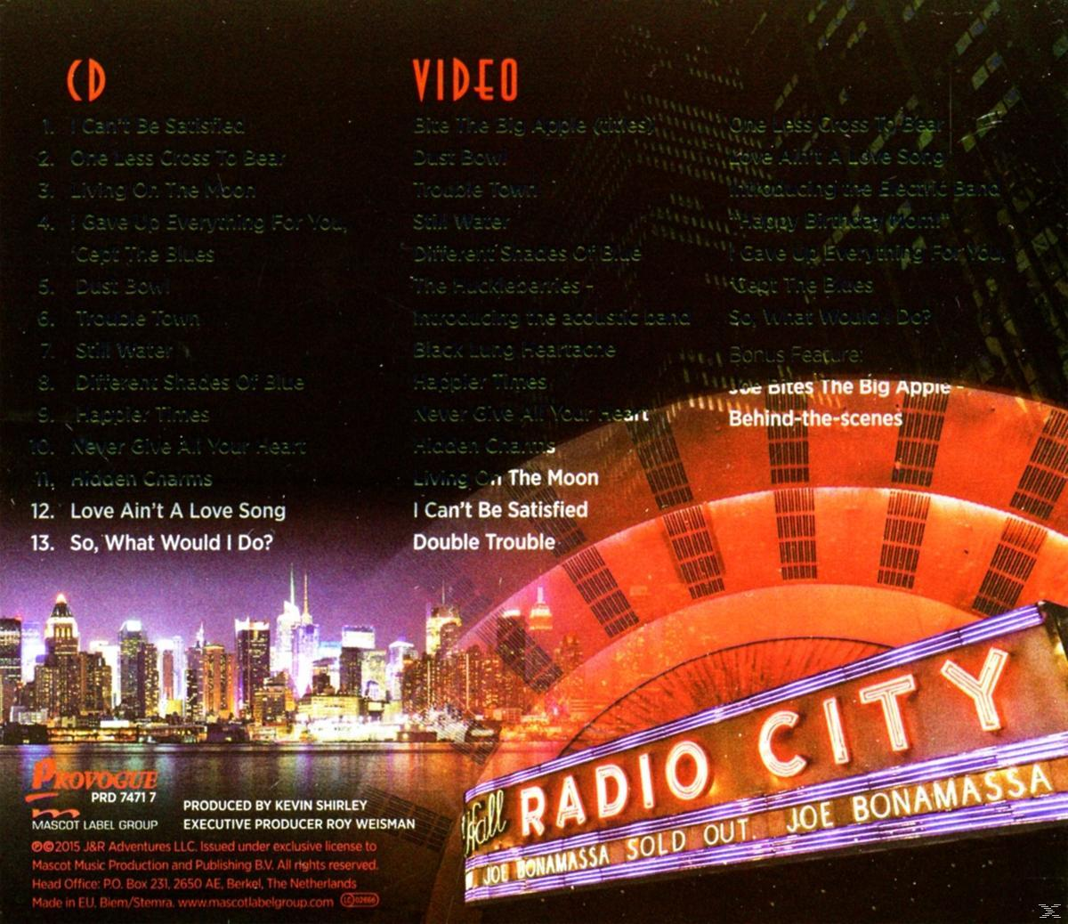 CD- und Video-Tracklisten auf einem Joe Bonamassa-Albumcover, mit einer Stadtsilhouette und einem Radio City-Schild.
