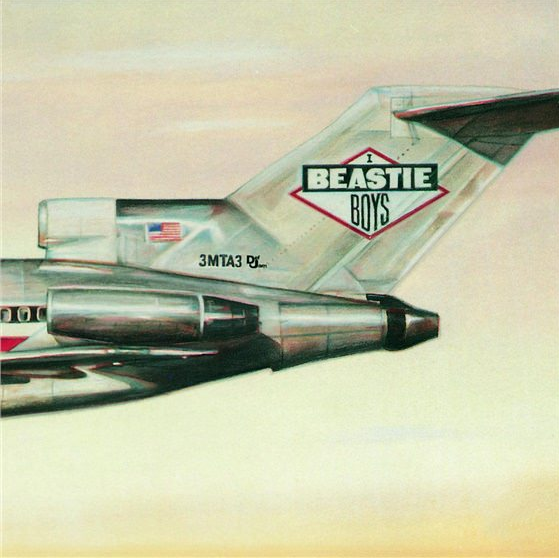 Vliegtuigstaart met "BEASTIE BOYS" in de lucht.