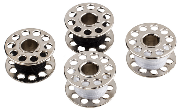 Four sewing machine bobbins, two with black thread, two with white, arranged on a white surface.