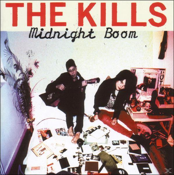 Albumhoes: Twee mensen op een bed, een speelt gitaar, een rommel van items op het bed.