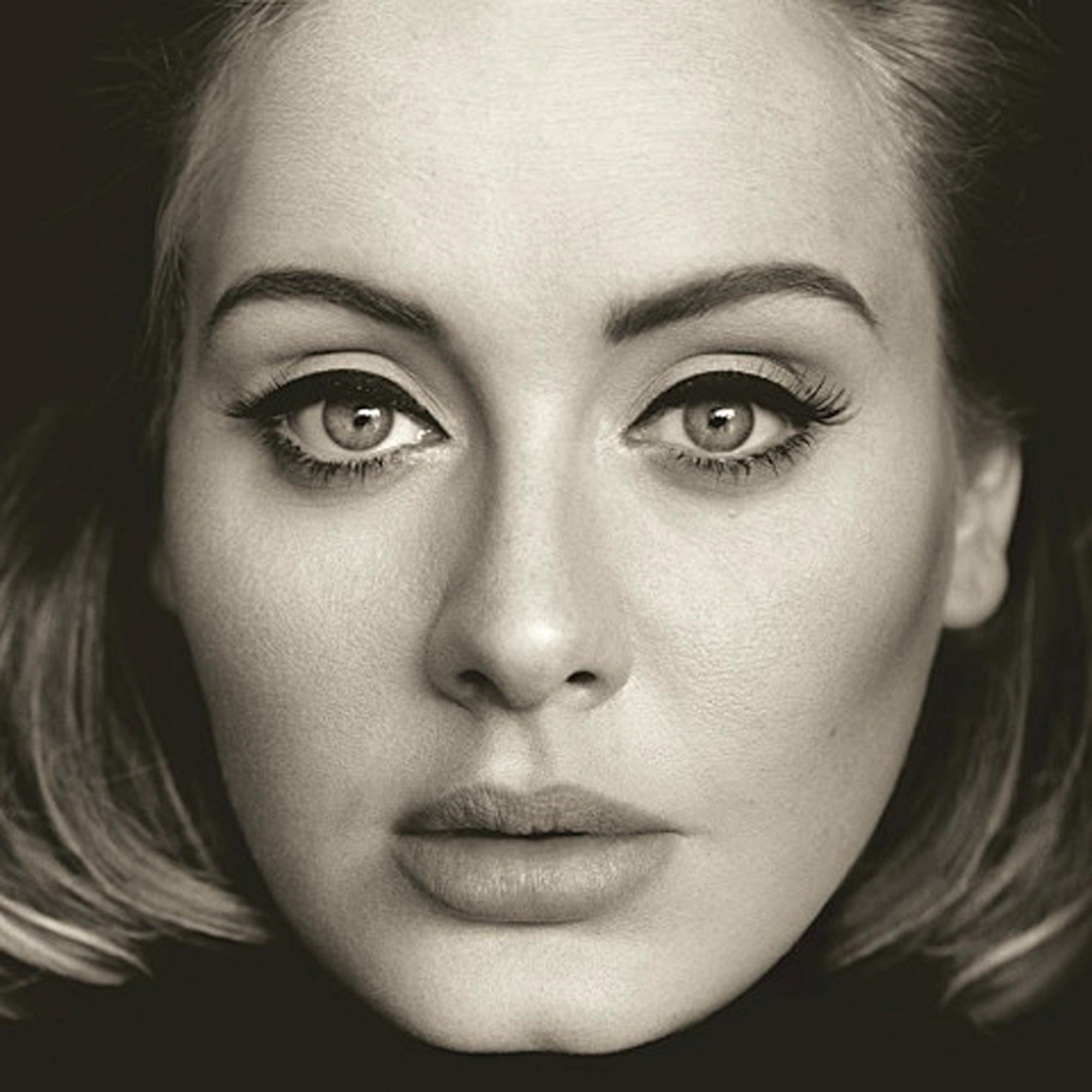 Portrait en gros plan d'Adele en ton sépia. Elle regarde la caméra avec un eye-liner foncé et des cheveux foncés.