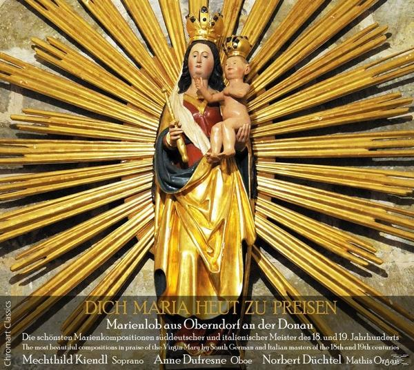 Goldene Statue der Maria mit Jesuskind, umgeben von goldenen Strahlen, mit Text unten.