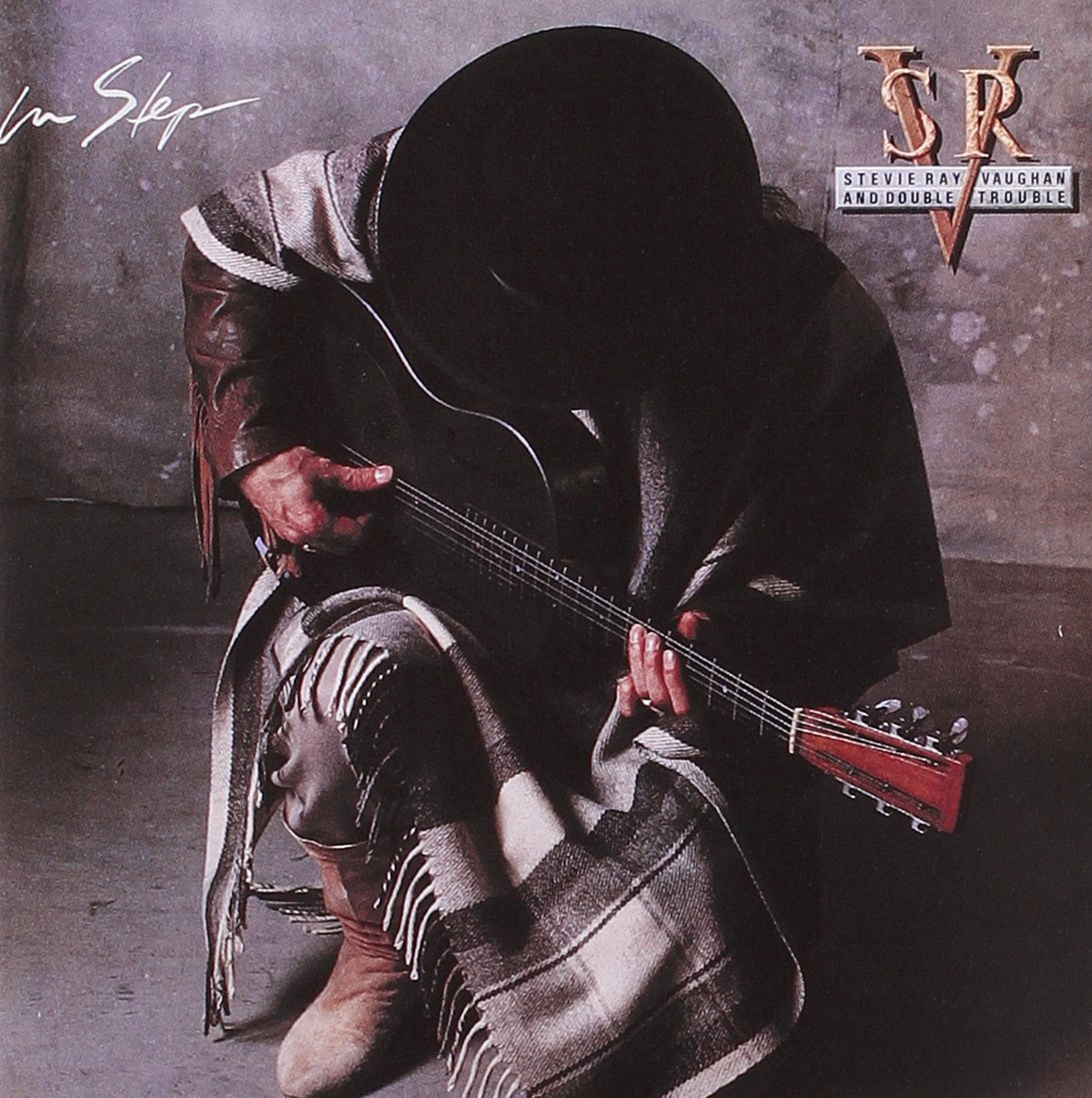 Albumcover mit Gitarre spielendem Mann, Hut und Decke tragend.