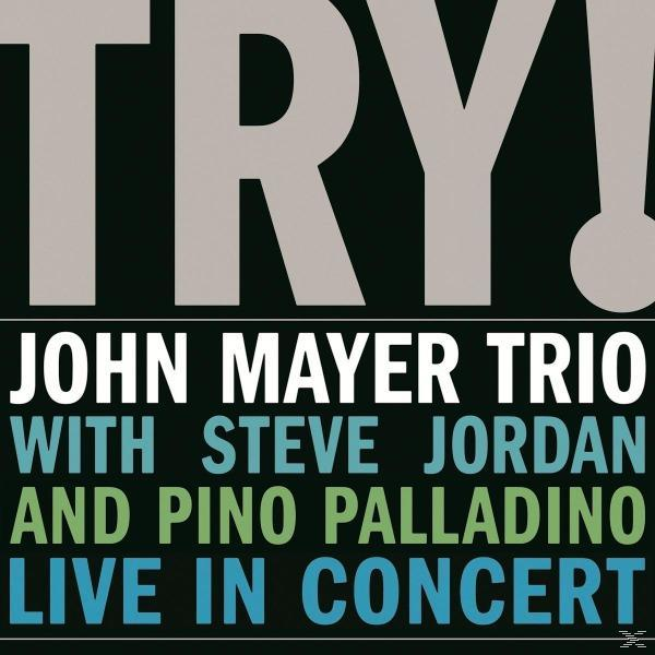 Album borító: 'TRY!' vastagon szedve, John Mayer Trio és koncert infó. Fekete háttér, kék és zöld szöveg.