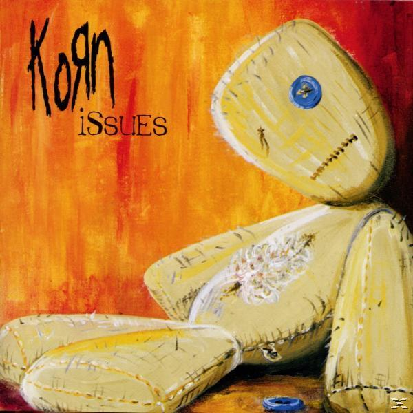 Albumcover für Korn's 'Issues'. Eine genähte Puppe auf orangefarbenem Hintergrund, mit dem Bandnamen.