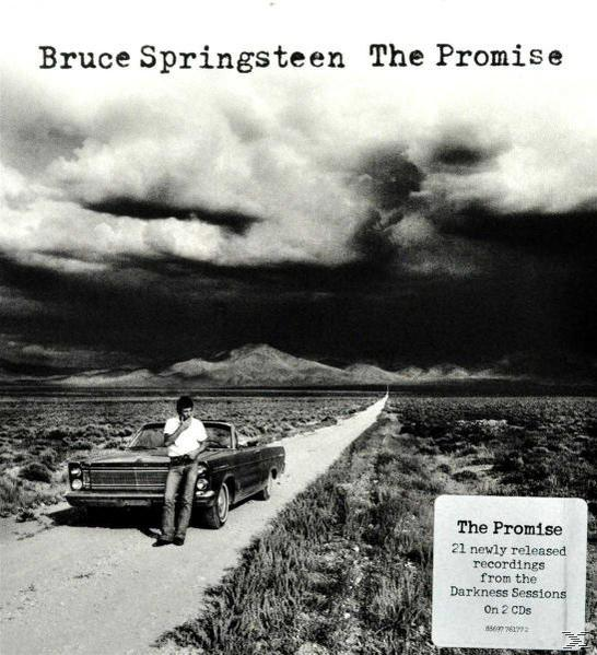 Albumcover: Bruce Springsteen steht an einem Auto auf einer langen Straße mit bewölktem Himmel. Titel: The Promise.