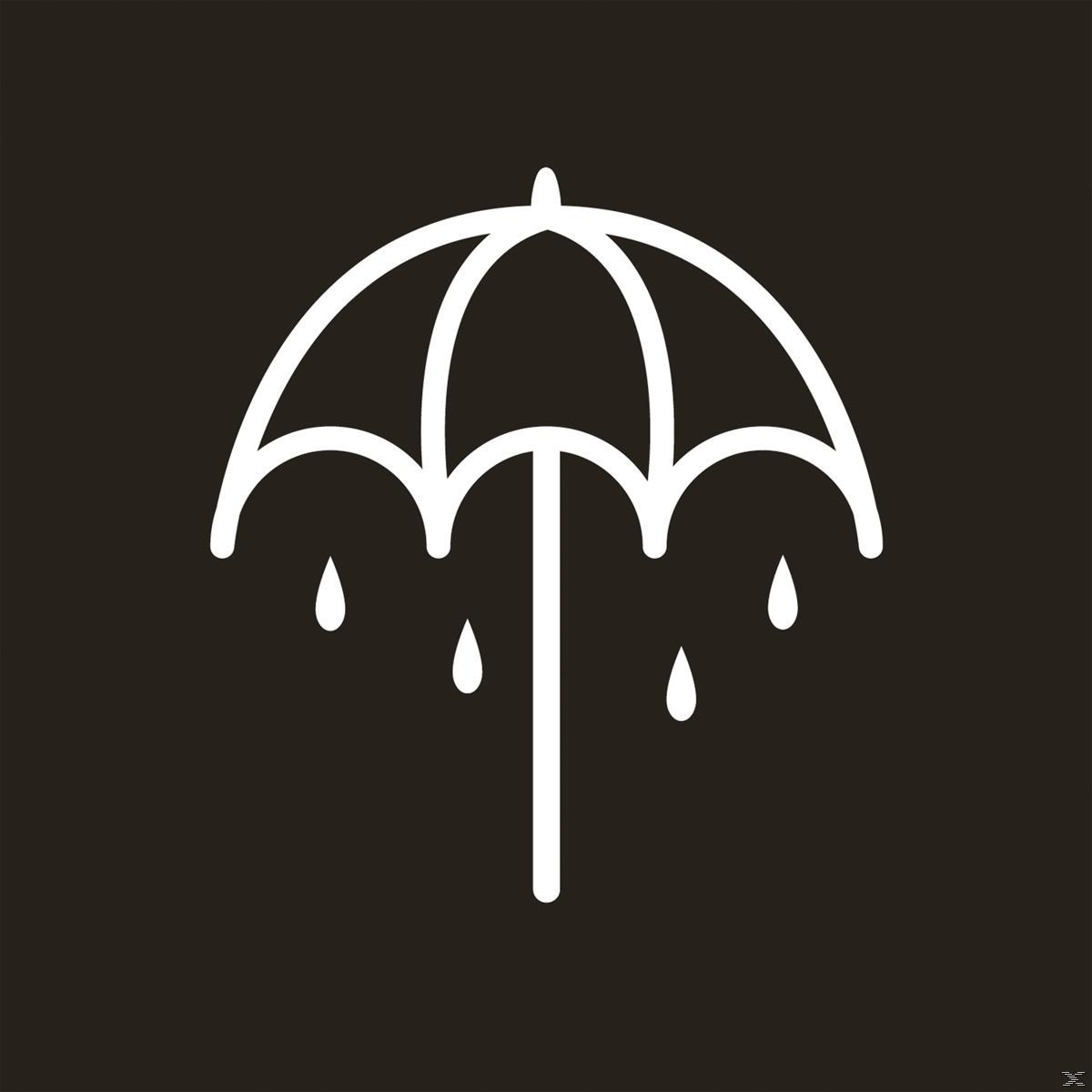 Weißer Regenschirm mit Regentropfen auf schwarzem Hintergrund. Der Schirm hat ein einfaches, minimalistisches Design.