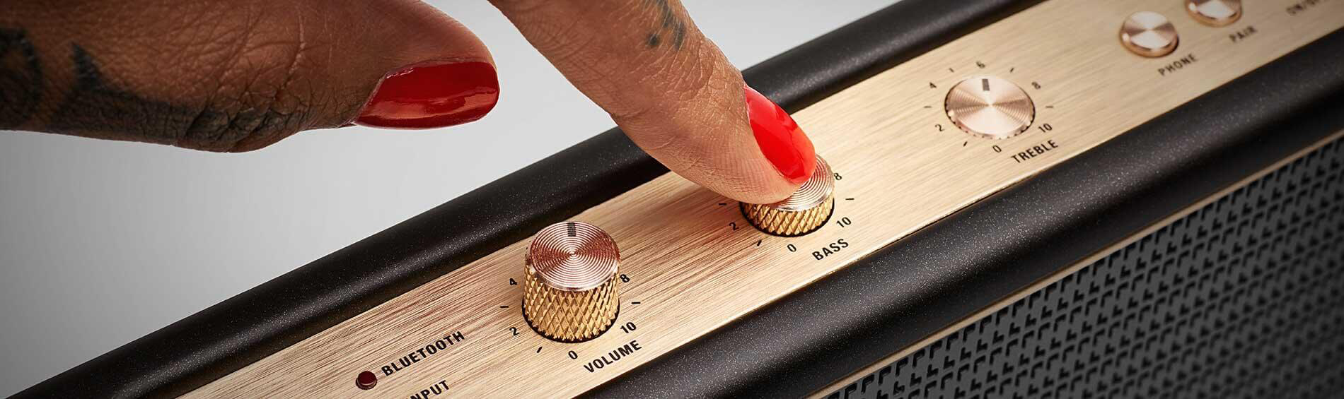 Un doigt appuyant sur un bouton d'un haut-parleur Marshall.