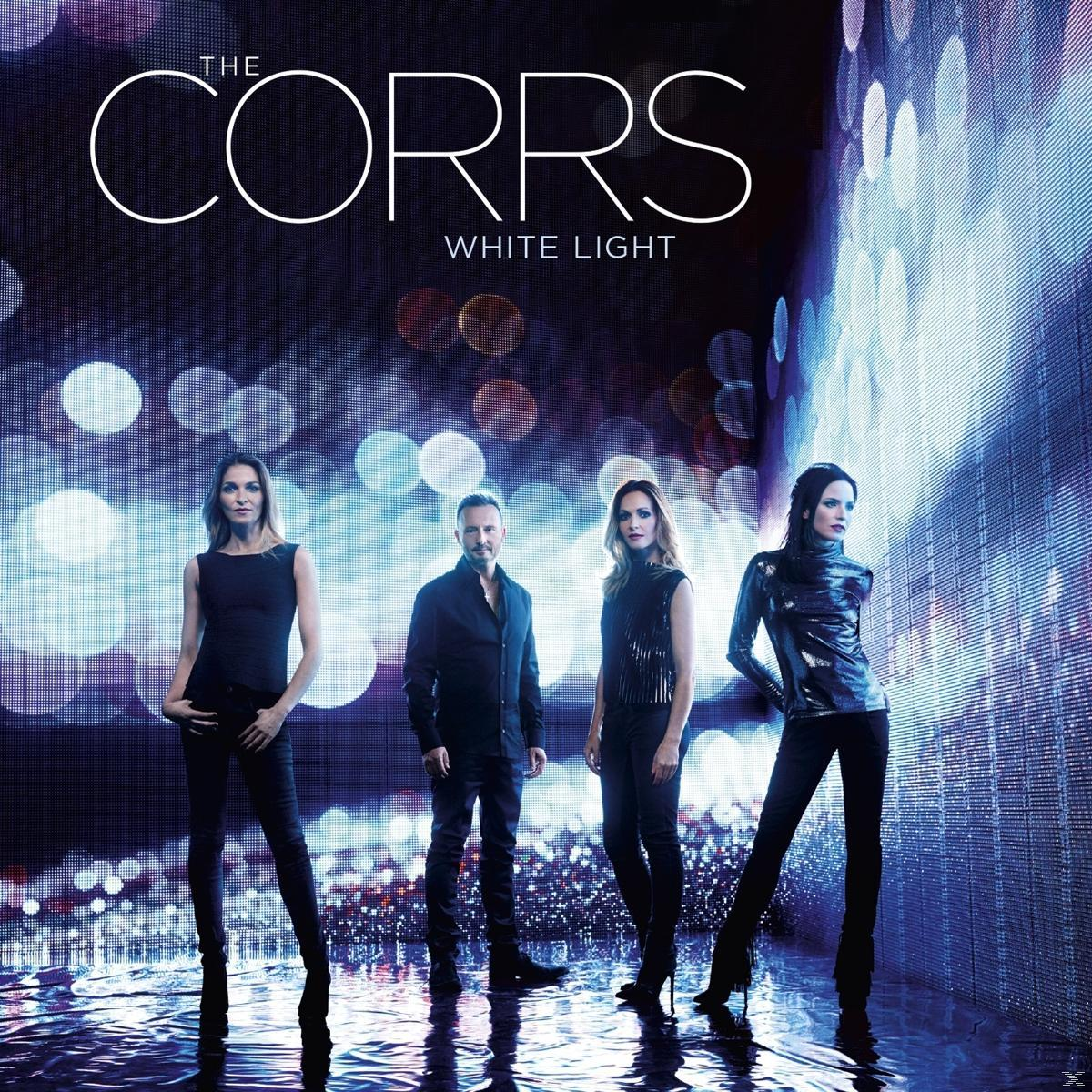 De albumhoes van The Corrs: vier mensen in zwarte outfits staan voor een vage, verlichte achtergrond.