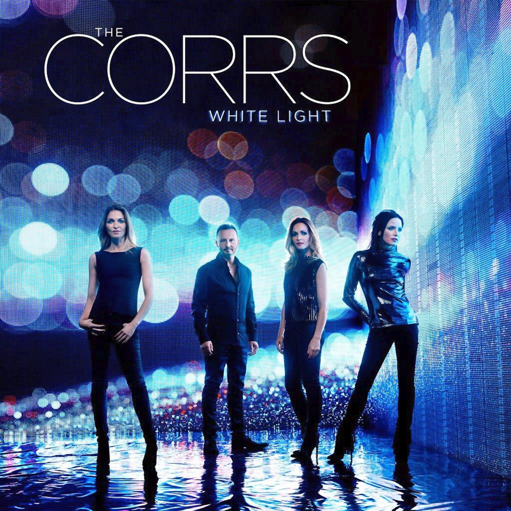 Albumhoes van The Corrs. Vier mensen staan voor een met licht gevulde muur, blauwe achtergrond met tekst. 'White Light'.