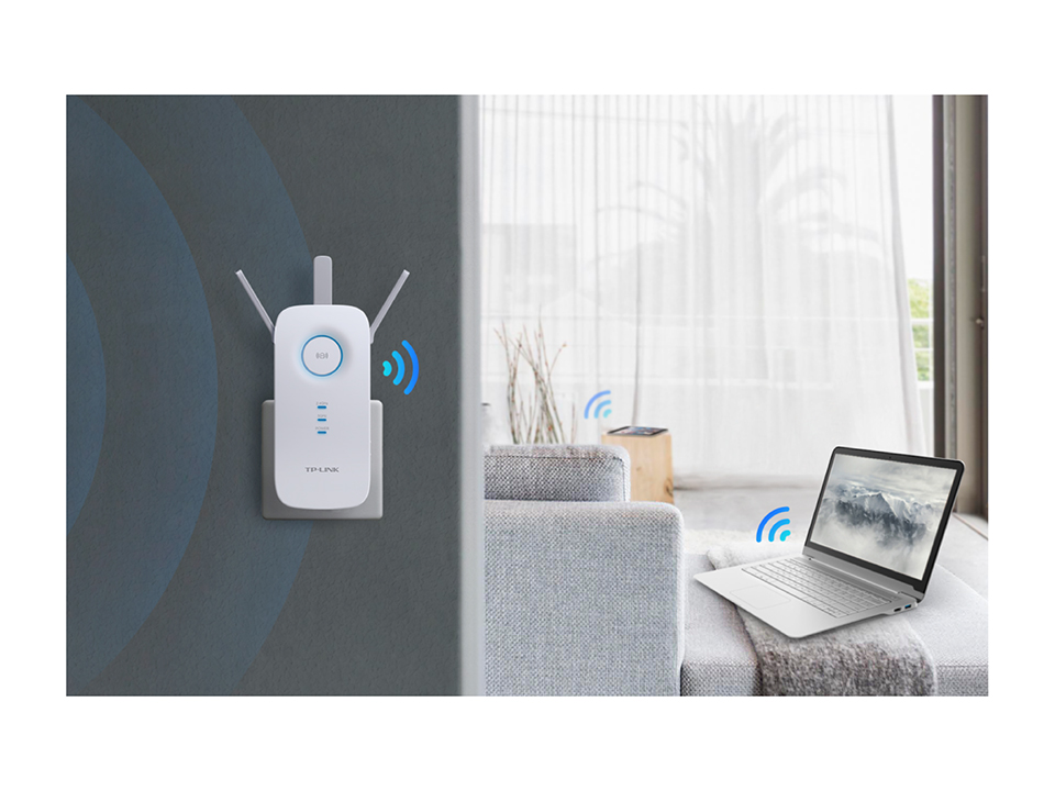WiFi extender plugged into a wall. A laptop and a couch are also in the room.
