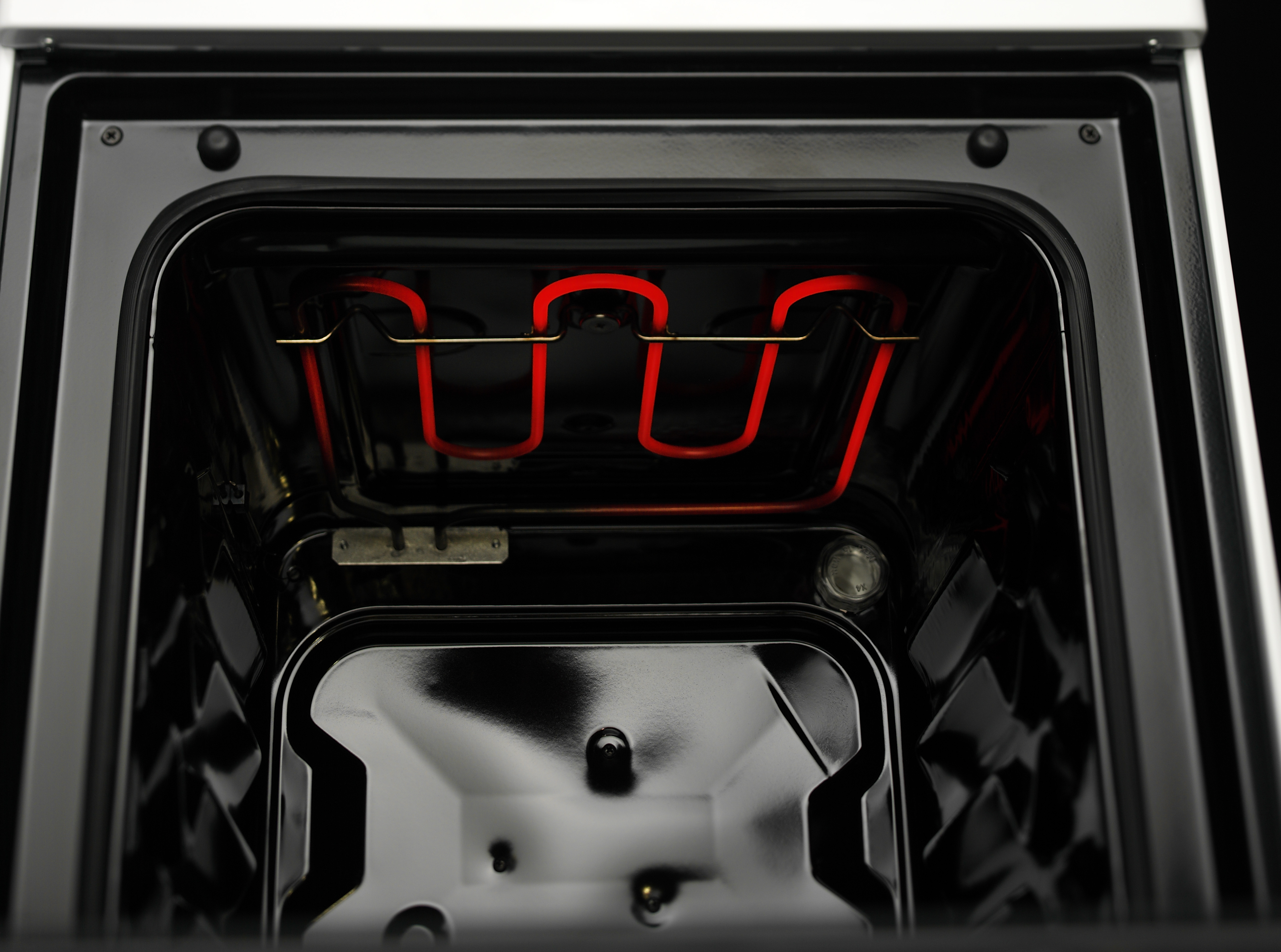 Oveninterieur met een rood verwarmingselement. Donker interieur, glanzende afwerking.