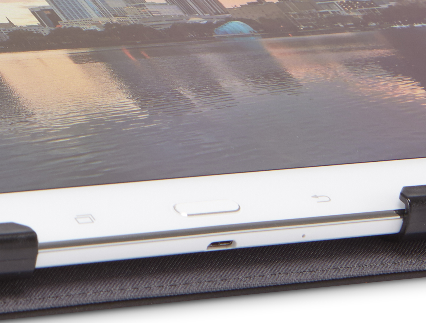Tablet detail: Witte lijst, zwarte hoes. Rivier en gebouwen weerspiegeld op scherm. Licht en schaduw.