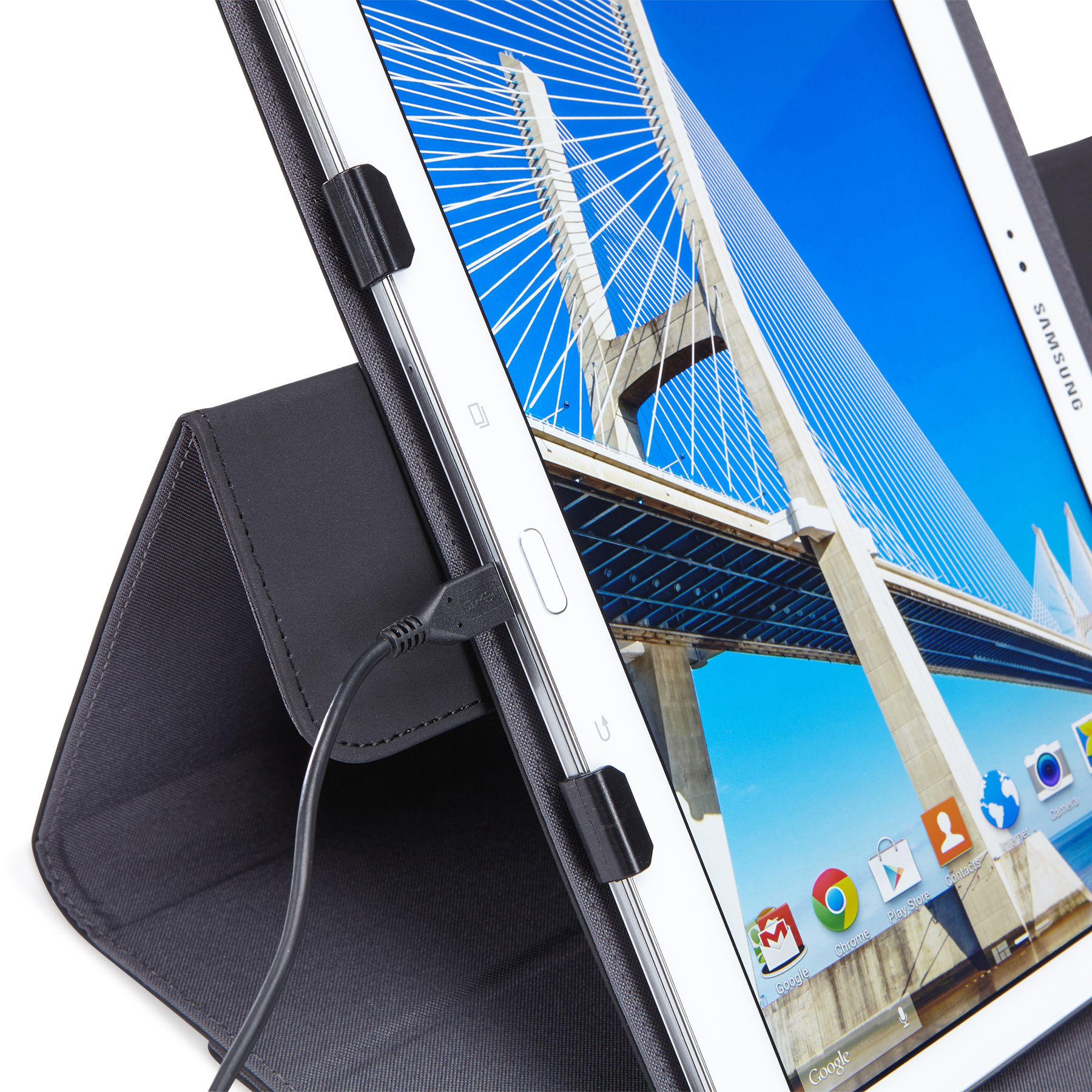 Tablet in hoes met oplaadkabel, achtergrond is een brug en blauwe lucht.