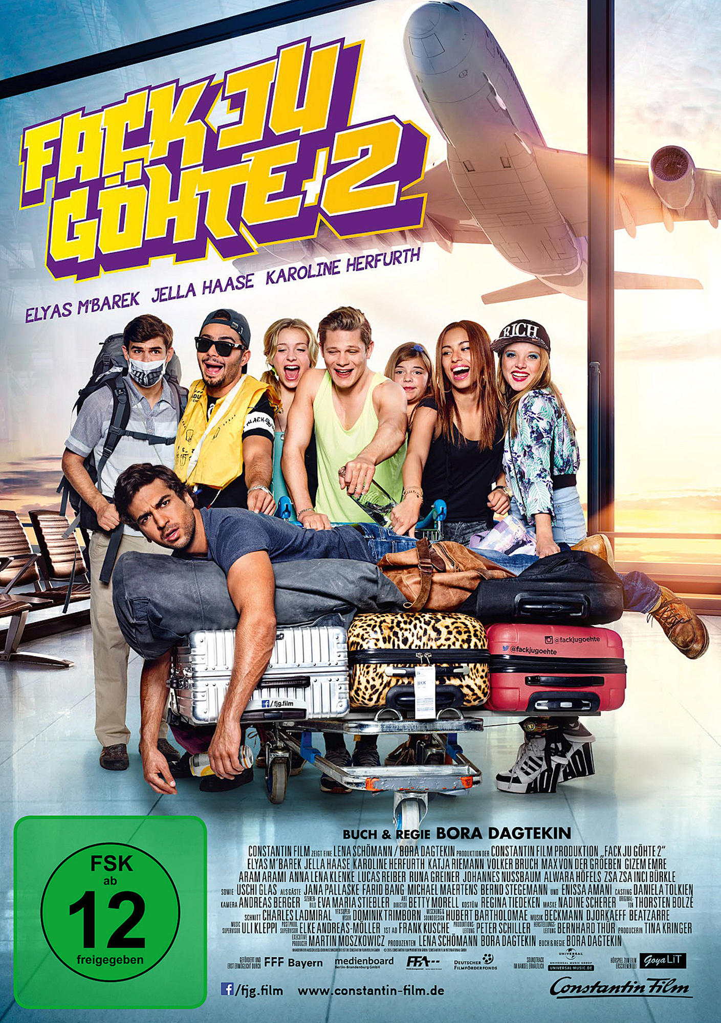 Filmcover. Gruppe von Leuten am Flughafen. Titel 'Fack Ju Göhte 2'. FSK 12 Bewertung. Flugzeug im Hintergrund.