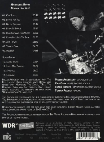 CD-Cover einer Live-Performance. Das Cover enthält eine Titelliste, Bandmitglieder und einen Schlagzeuger.