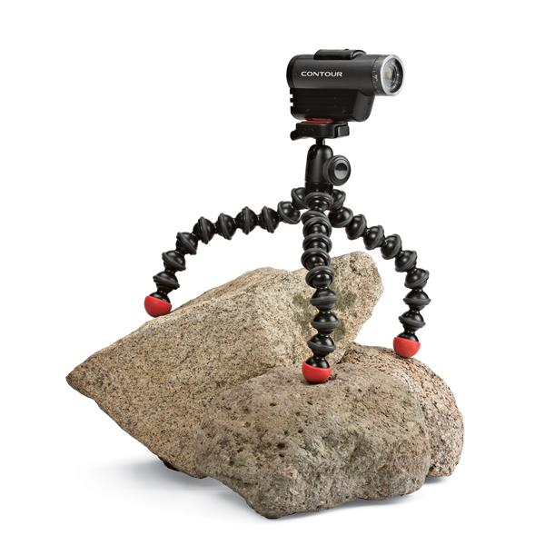 Black camera on a flexible tripod, on a rock. White background.