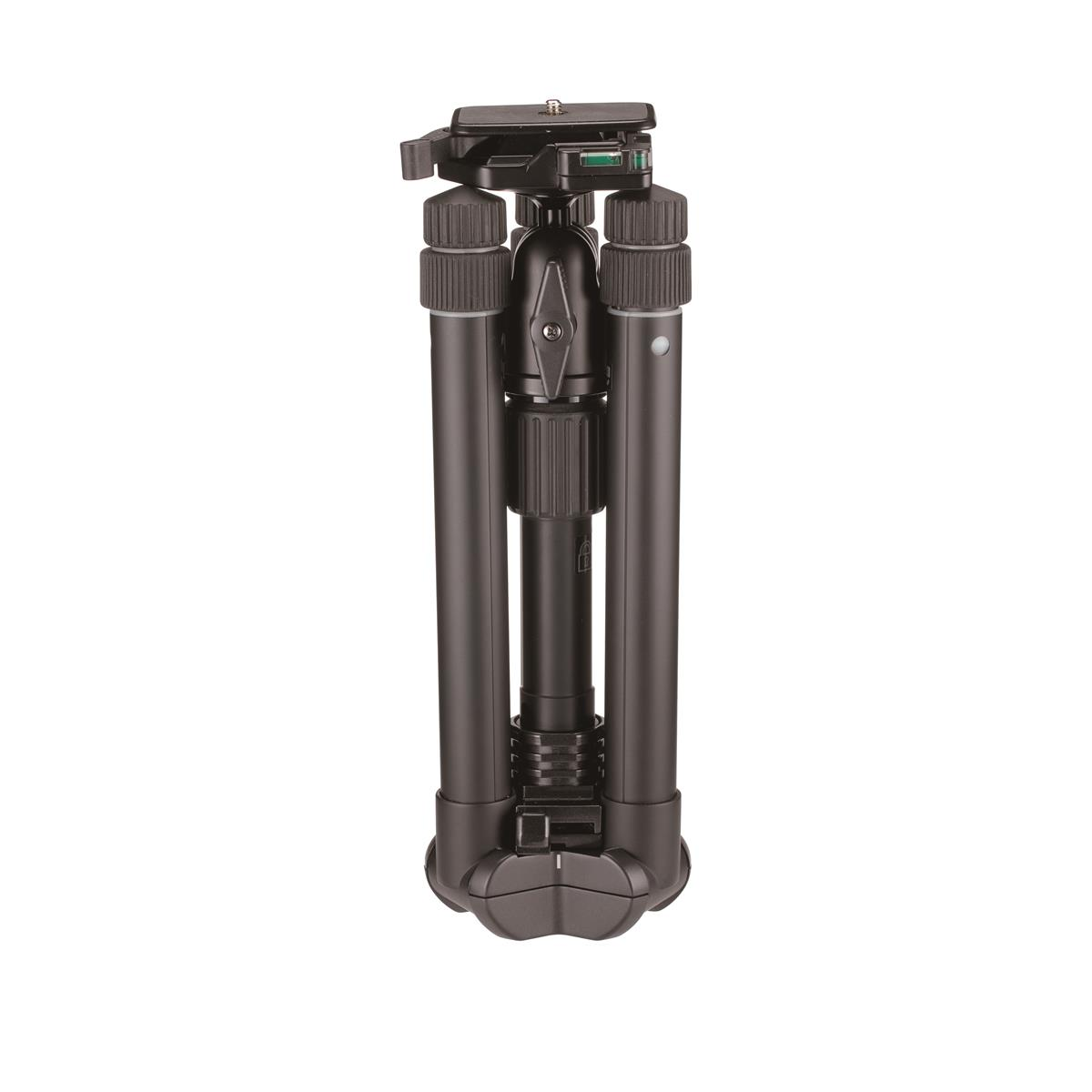 A black tripod is standing on a white background. The tripod is folded with three legs and a head for mounting a camera.