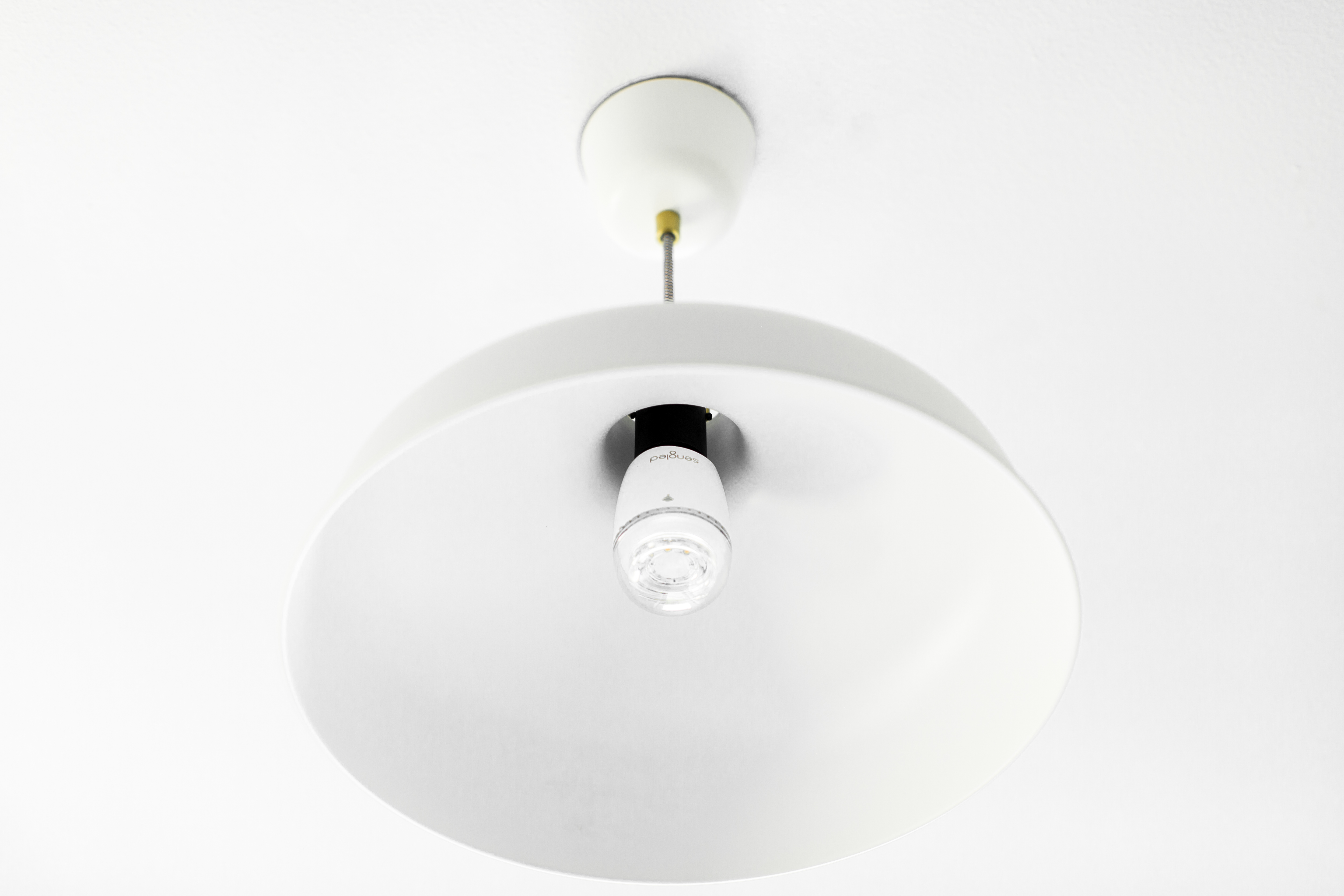 A white ceiling lamp hangs from the ceiling. The lamp has a large, white shade and a clear lightbulb.