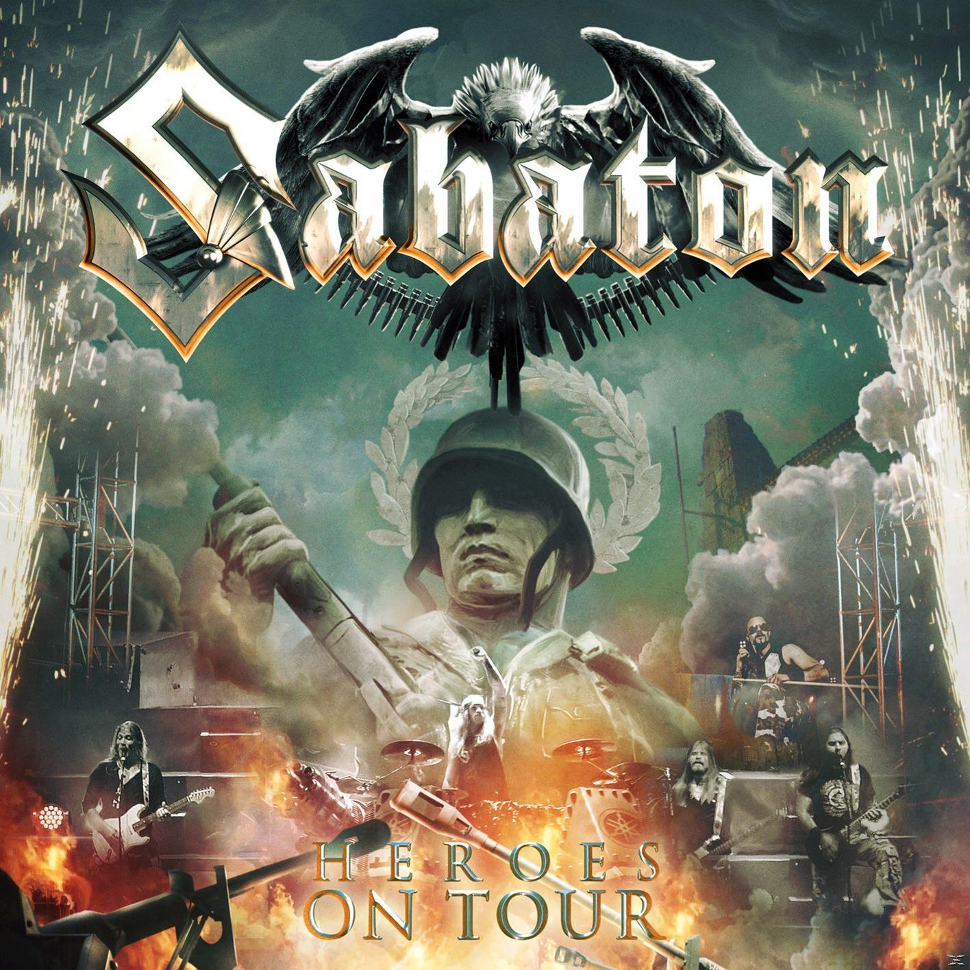 Sabaton Heroes On Tour Albumcover. Bandmitglieder performen auf der Bühne mit Feuer und Explosionen.