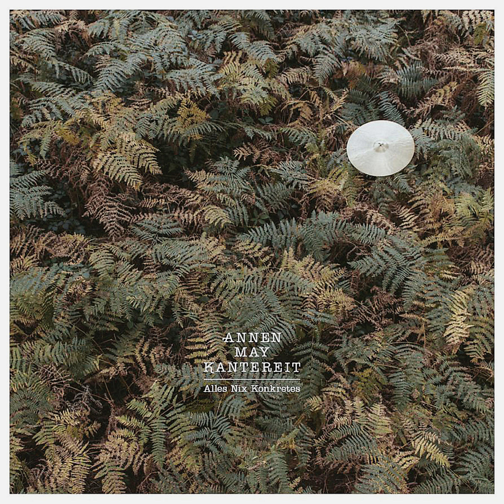 Annen May Kantereit Albumcover. Farne bedecken den größten Teil des Bildes mit einem weißen Objekt obenauf.