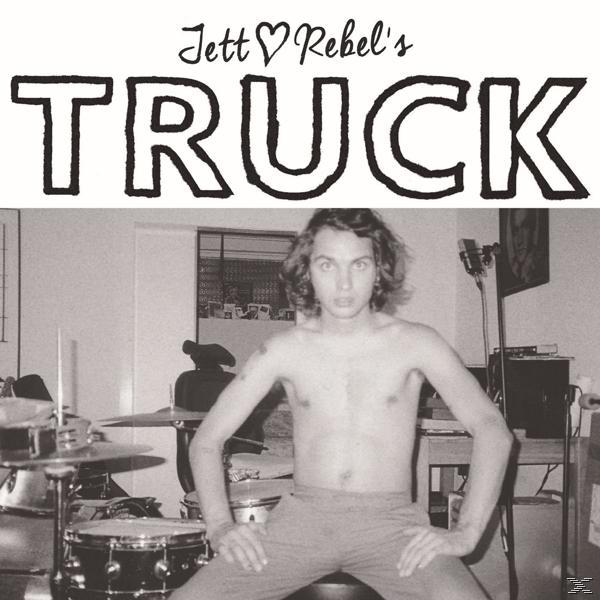 Zwart-witfoto van een man met lang haar die ontbloot bovenlijf zit. Tekst 'Jett Rebel's TRUCK' staat bovenaan. Drums zijn zichtbaar.