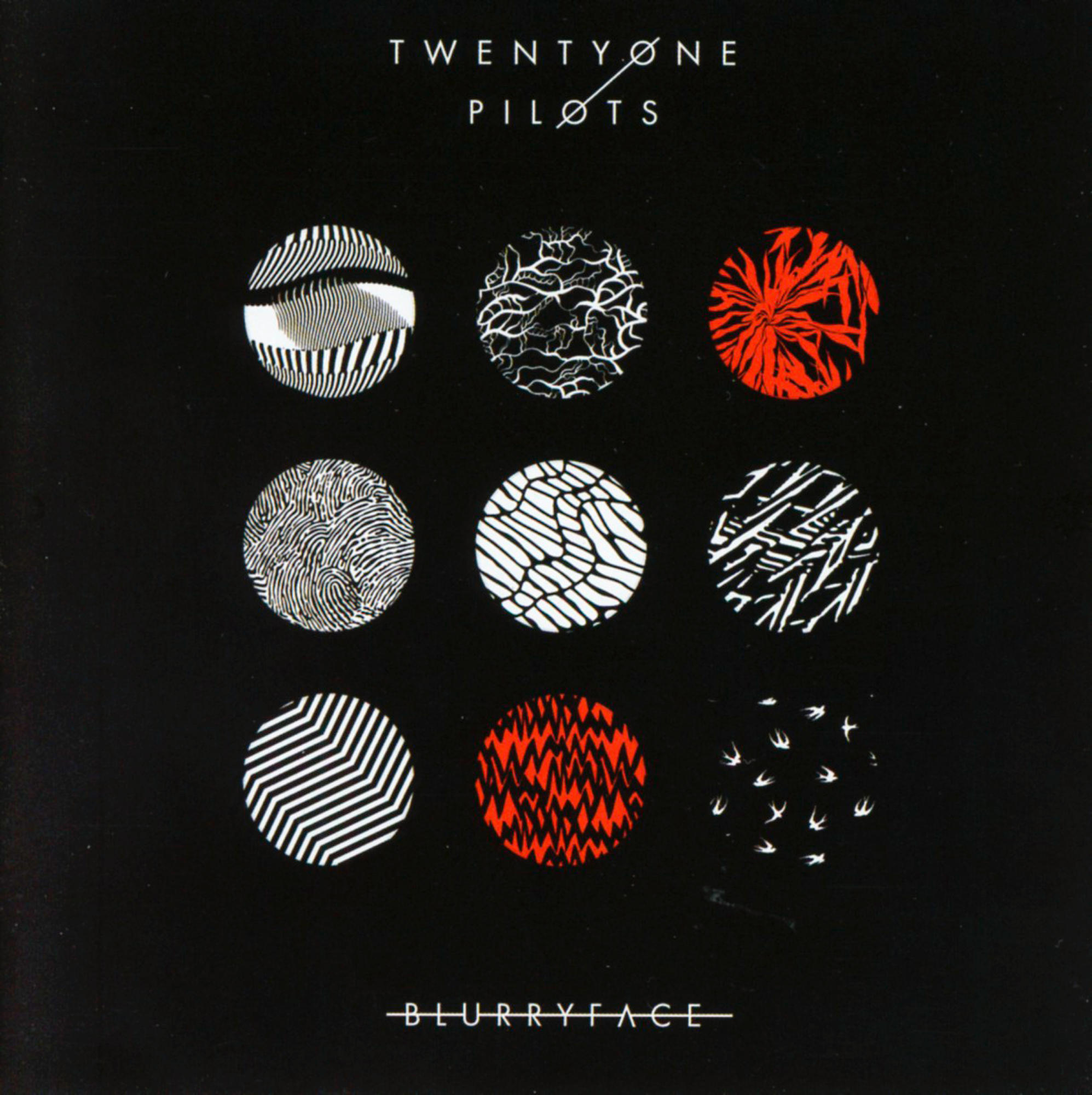 Albumhoes met negen kleurrijke cirkels op een zwarte achtergrond. Bandnaam: Twenty One Pilots.