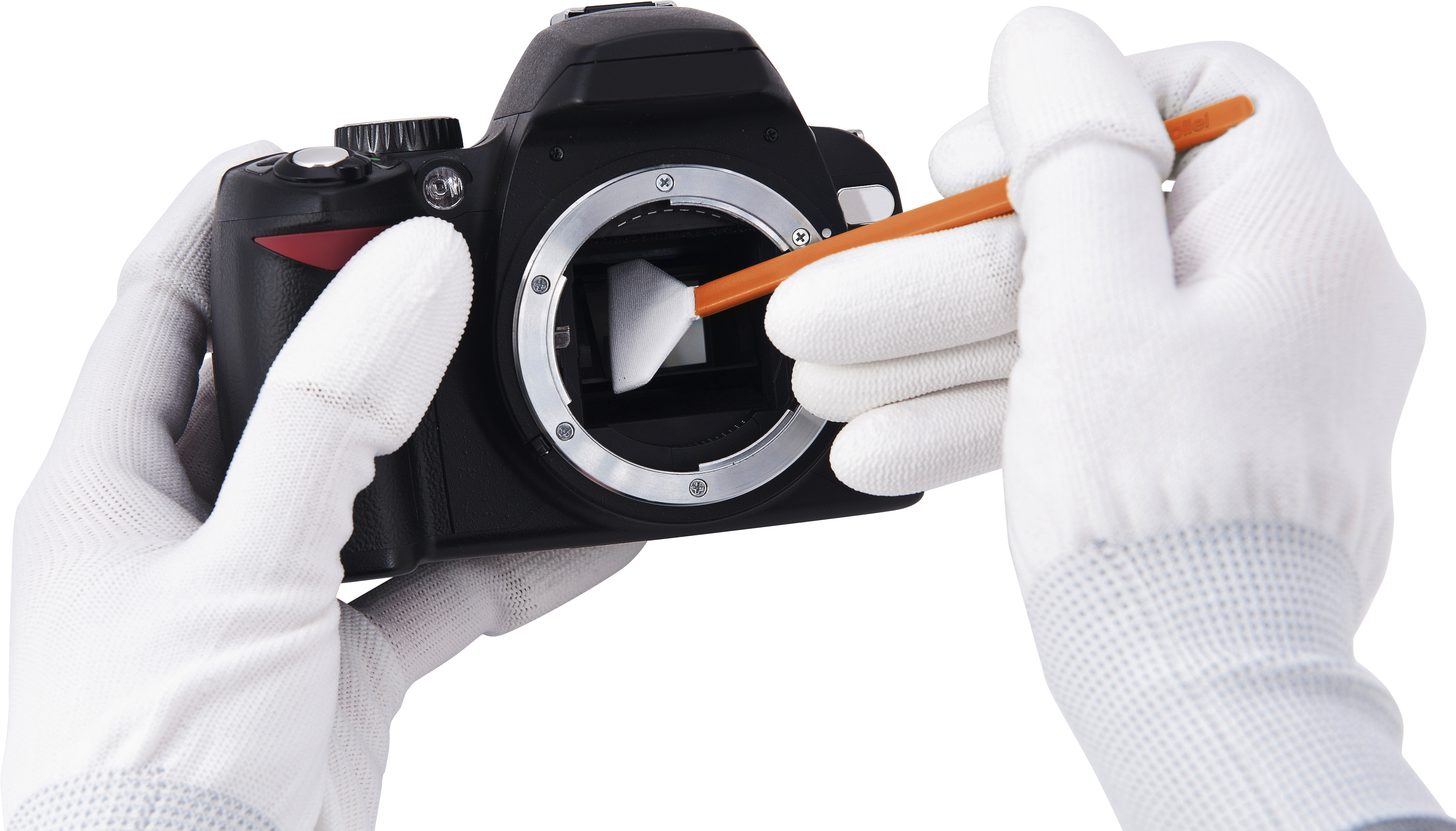 Eine Person mit weißen Handschuhen reinigt das Innere einer schwarzen DSLR-Kamera mit einem Pinsel.
