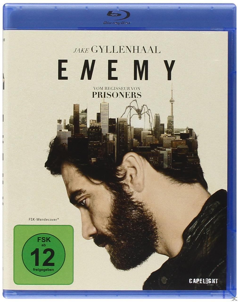 Filmcover: Jake Gyllenhaal's Gesicht. Text: Enemy. Stadtsilhouette auf seinem Kopf. Blu-ray-Hülle.