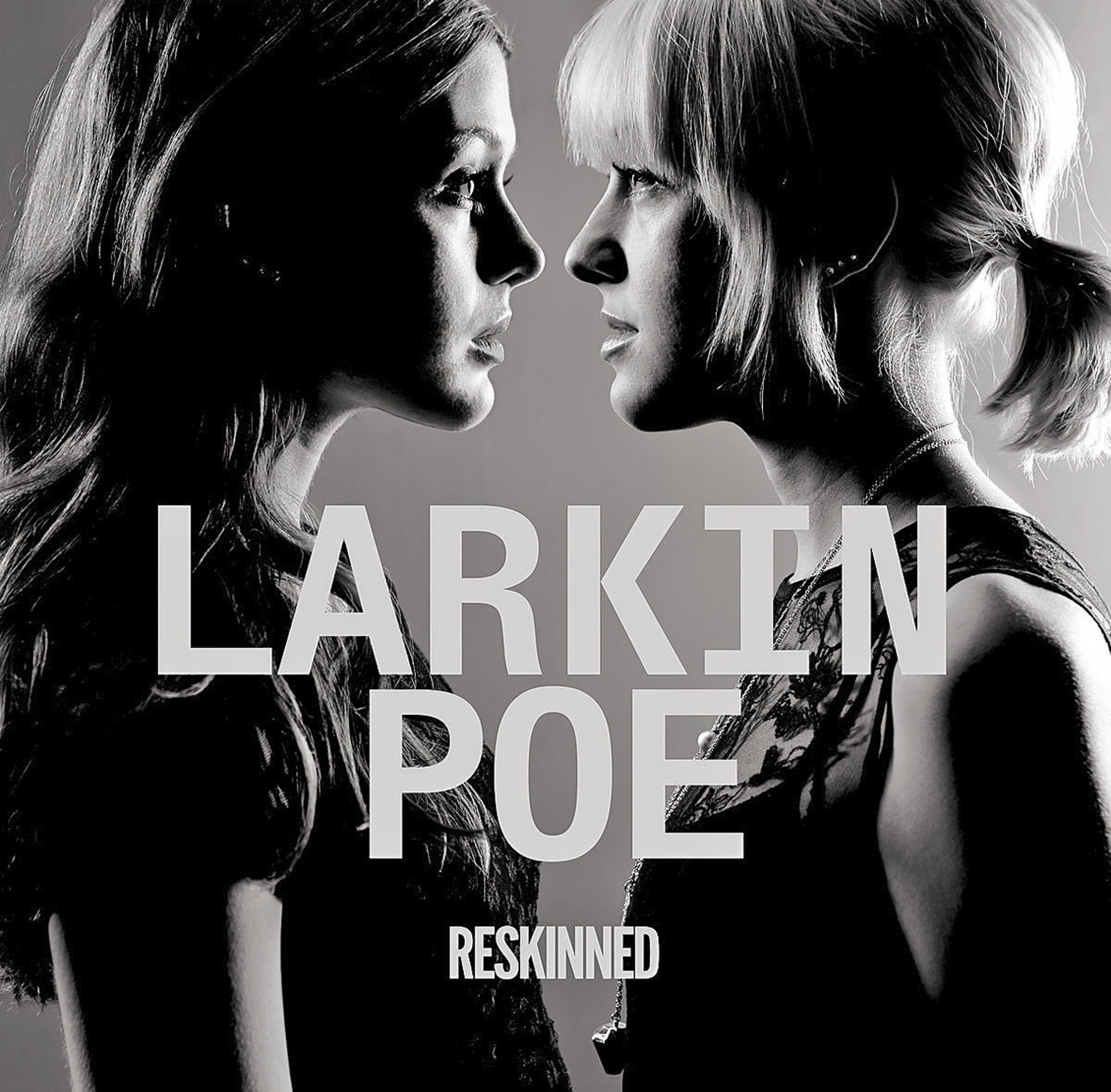 Schwarz-Weiß-Bild von zwei Frauen, die sich gegenüberstehen. Text darüber lautet "Larkin Poe" und "Reskinned".