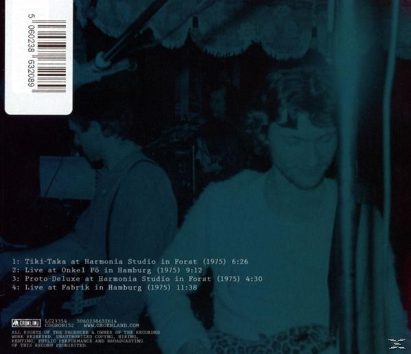 Zwei Männer in gedämpfter Umgebung. Text über Live-Musik-Auftritte ist auf verschwommenem Hintergrund sichtbar, mit Barcode links oben.