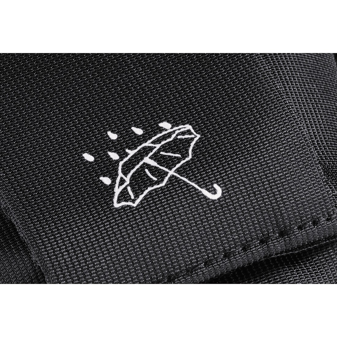 Embroidered umbrella logo on a black fabric. White stitching and a rain drop design.