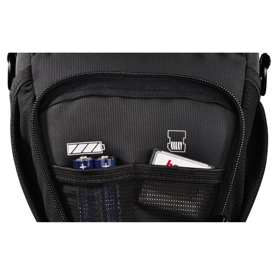 Black backpack pocket with batteries, a card, and mesh. The zipper is closed. Dark background.