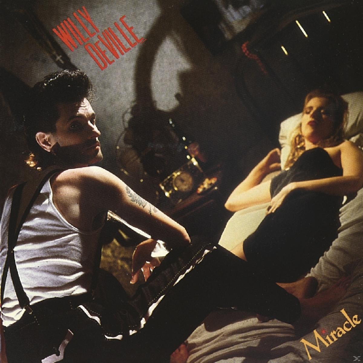 Albumcover mit einem Mann, der Gitarre spielt und eine Frau auf einem Bett ansieht. Vintage-Setting.