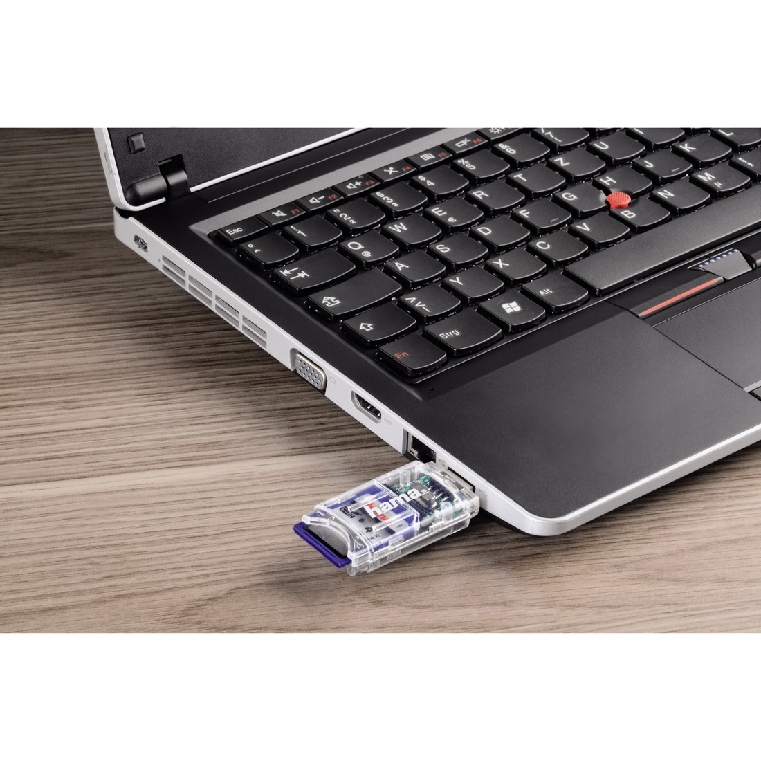 Ordinateur portable avec une clé USB branchée. L'ordinateur portable est sur une surface en bois.