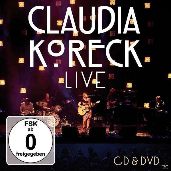 Claudia Koreck auf der Bühne. CD und DVD befinden sich am unteren Bildrand.