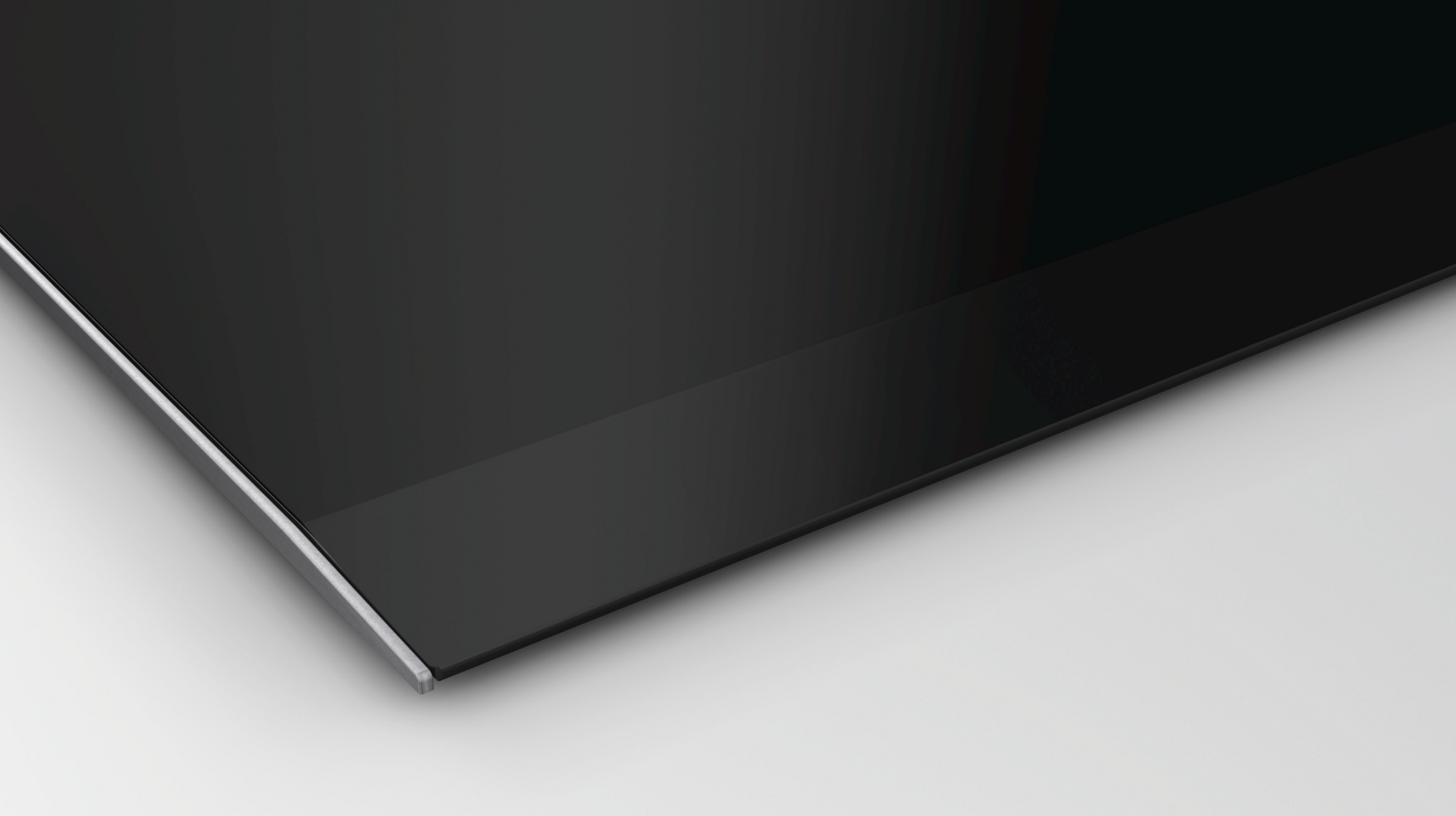 Gros plan d'une surface en verre noir avec un bord métallique fin.