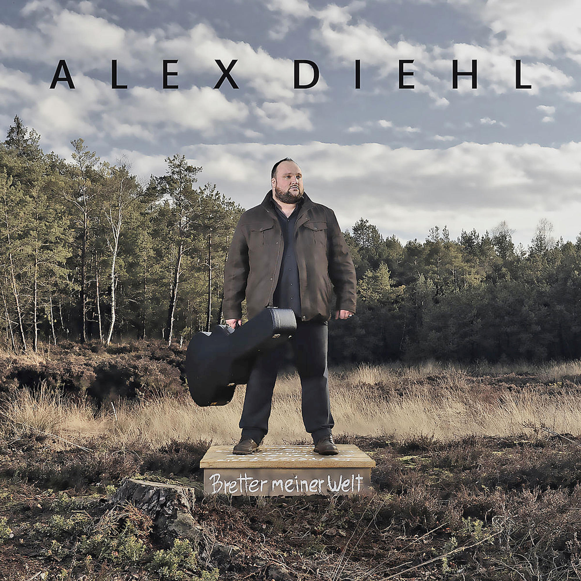 Albumcover: Mann mit Gitarrenkoffer steht auf Bühne. Waldhintergrund, Alex Diehl Titel.