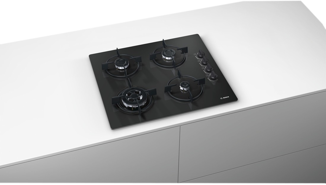 Fekete, beépített főzőlap négy égővel, fehér felületen, letisztult, modern design.