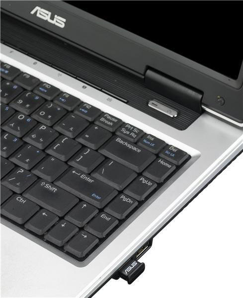 Laptop-Tastatur, schwarze Tasten, silberner Rahmen. USB-Port-Adapter eingesteckt.