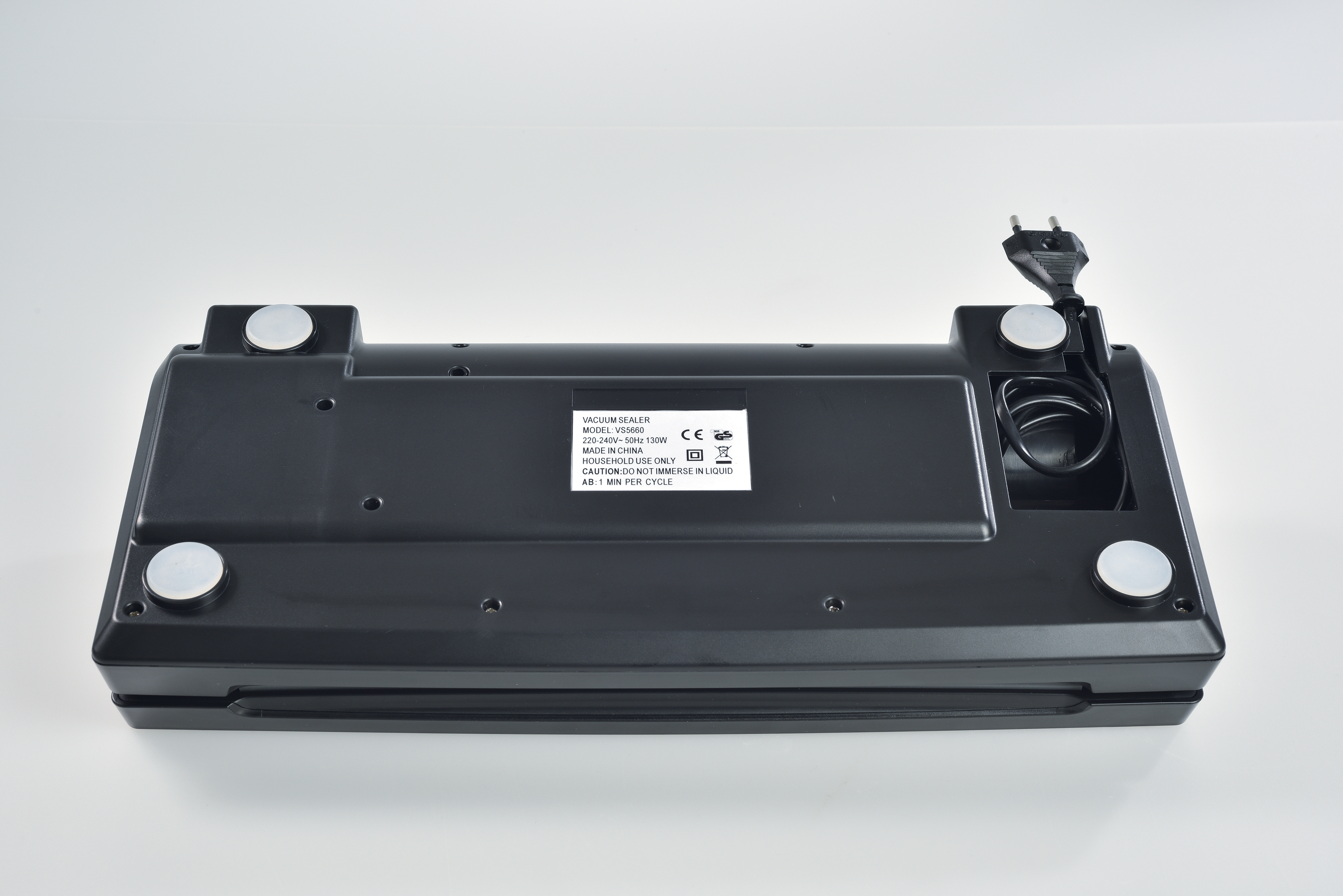 Zwarte vacuümsealer, onderaanzicht, witte achtergrond. Functies zijn netsnoer, rubberen voetjes en productlabel.