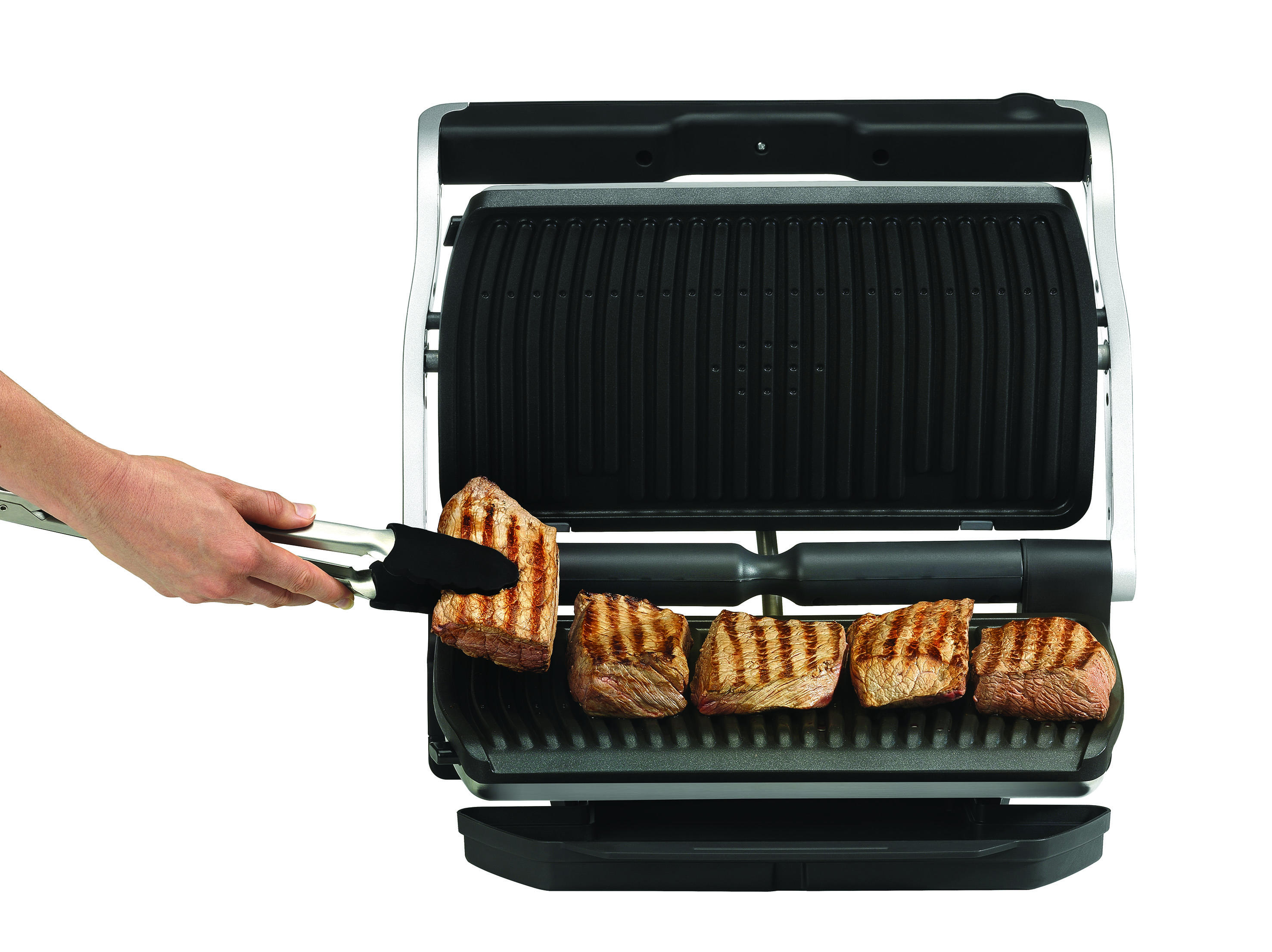 Offener Grill mit Steaks. Hand mit Zange. Grill ist schwarz, Steaks sind gegrillt, weißer Hintergrund.