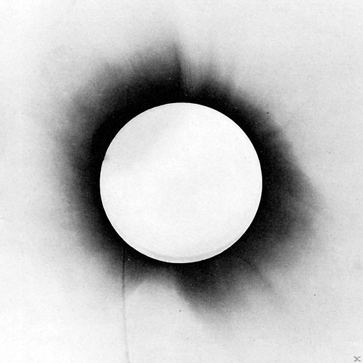 Weißer Kreis auf weißem Hintergrund, umgeben von einem dunklen, verschwommenen Halo.