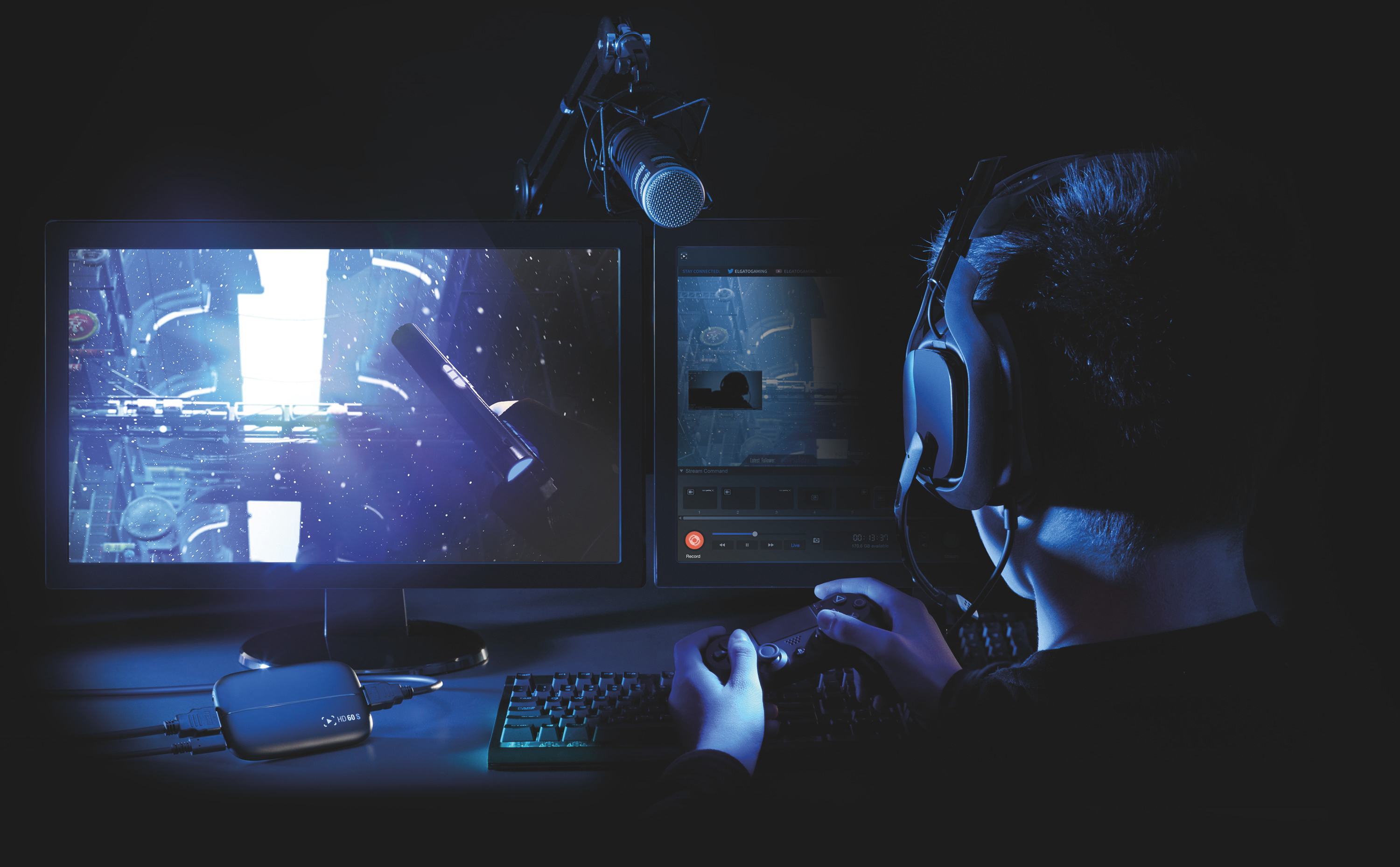 Spieler spielt auf zwei Monitoren mit Mikrofon. Dunkler Raum mit blauer Beleuchtung.