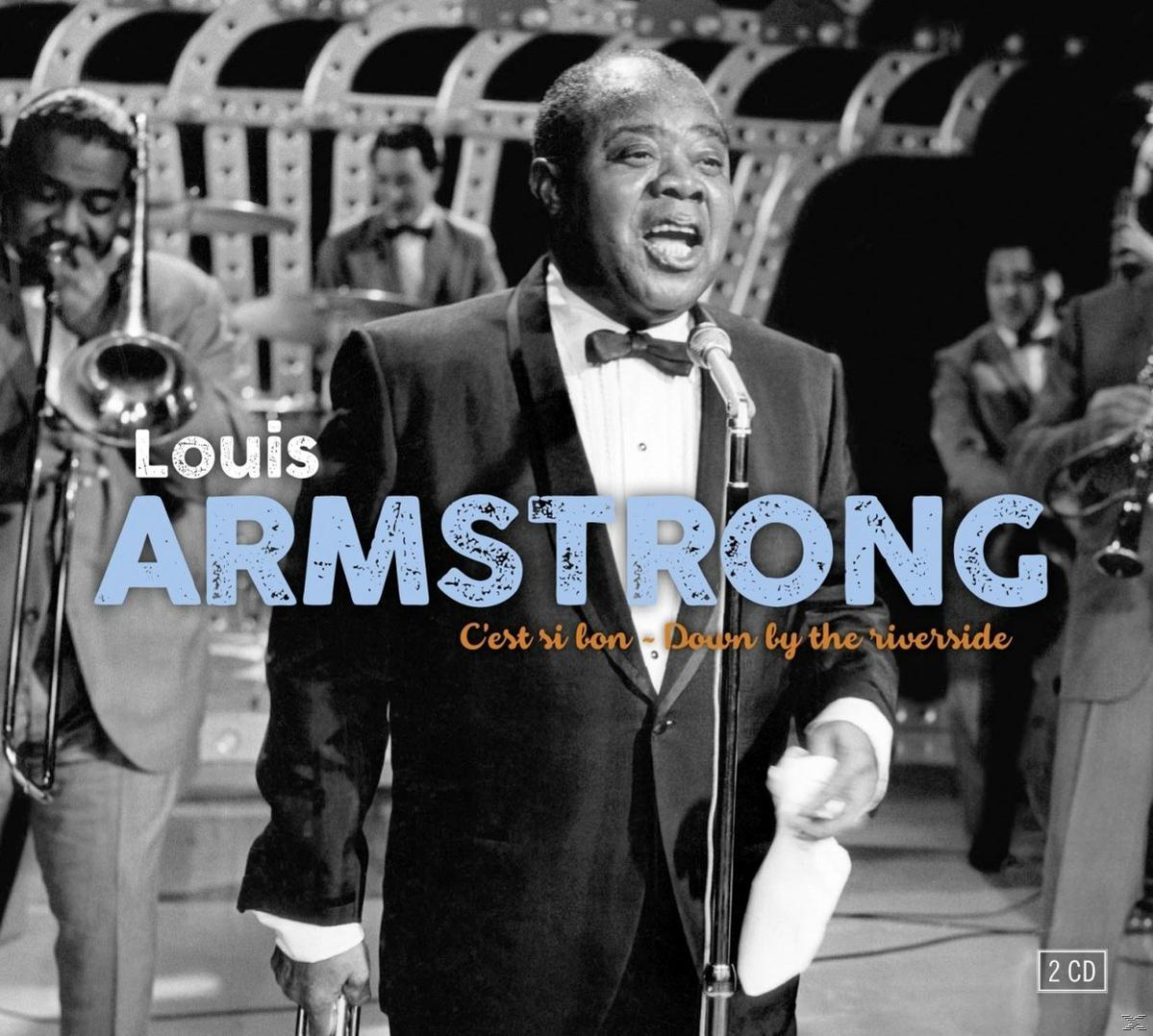 Louis Armstrong sur scène. Un homme en costume chante dans un micro, avec son groupe.