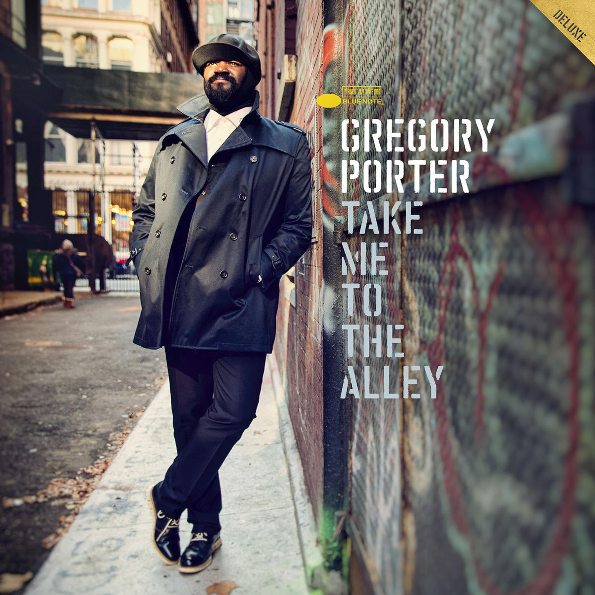Pochette de l'album de Gregory Porter, 'Take Me to the Alley'. Homme en manteau noir, adossé à un mur de briques, ruelle.