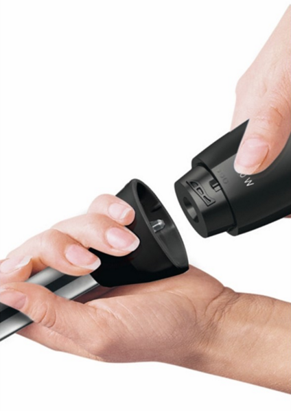 Mains connectant un accessoire noir et argenté à un appareil noir. La mise au point est sur les mains.